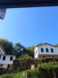 a view of two white houses with a fence at República Engenho Quarto Triplo II in Ouro Preto