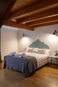 a bedroom with a large bed in a room with wooden ceilings at Hotel Palacio Barón de Andilla in Valdealgorfa +80 photos