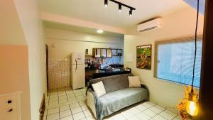 a living room with a couch and a kitchen at Umbelino Moradia in Santarém