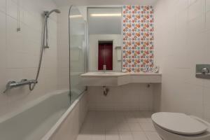 a bathroom with a toilet and a sink and a shower at Skiathos Palace Hotel in Koukounaries