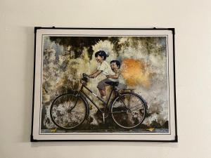 a painting of a man and a woman riding a bike at Phoenix homestay in Varkala