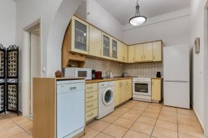 a kitchen with yellow cabinets and a washer and dryer at Kaminaki Villas by Tsiolis Family in Katávolos +80 photos
