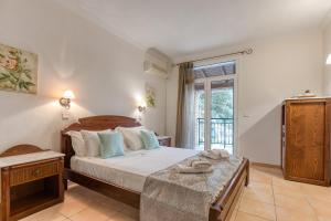 a bedroom with a large bed and a window at Kaminaki Villas by Tsiolis Family in Katávolos