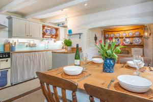 une cuisine avec une table en bois et des chaises ainsi qu'une salle à manger dans l'établissement Tri Pysgodyn, à Haverfordwest 26 autres photos