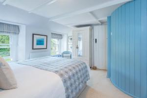 une chambre avec un lit et un mur bleu dans l'établissement Tri Pysgodyn, à Haverfordwest