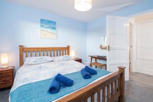 a bedroom with a bed with blue towels on it at Afallon in Haverfordwest