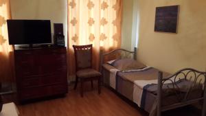 a bedroom with two beds and a tv and a dresser at Lemon Family GuestHouse in Tbilisi City
