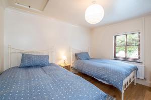 Un dormitorio con dos camas y una ventana. en Coastal View, en Haverfordwest