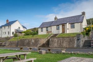 una casa con una pared de piedra frente a un edificio en Coastal View, en Haverfordwest