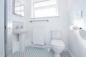 Un baño blanco con inodoro y lavabo. en Awel Y Mor, en Newport