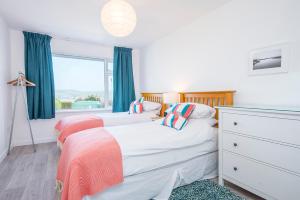 2 camas individuales en un dormitorio con ventana en Awel Y Mor, en Newport