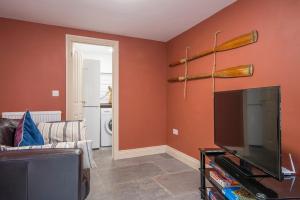 Una sala de estar con un sofá y un televisor de pantalla plana. en Welford, en Newport