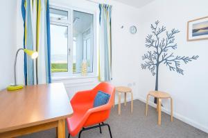 un comedor con mesa y sillas y un árbol en la pared en Awel Y Mor, en Newport