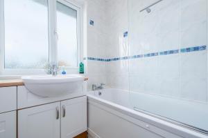 a white bathroom with a sink and a bath tub at Cherry Tree House in Haverfordwest +25 photos