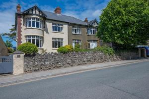 a large house with a stone wall in front of a street at Gorwel in Haverfordwest