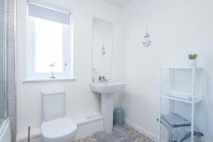 Un baño blanco con inodoro y lavabo. en Sandy-Rise, en Haverfordwest
