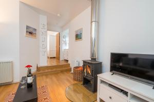a living room with a fireplace and a television at Picture Cottage in Solva