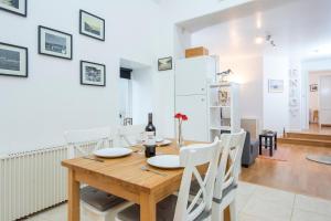 a kitchen and dining room with a wooden table and chairs at Picture Cottage in Solva