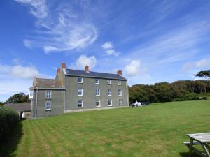 a large building on a grass field with a picnic table at Picture Cottage in Solva