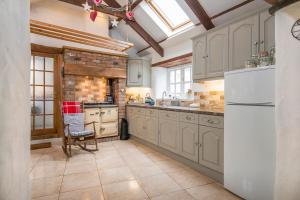 a kitchen with white cabinets and a white refrigerator at The Old Dairy in Haverfordwest