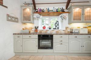 a kitchen with white cabinets and an oven at The Old Dairy in Haverfordwest +32 photos