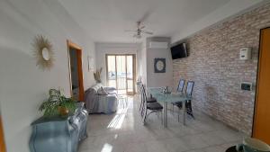 a living room with a table and a brick wall at Appartamento - Tocca il Mare in Marina di Strongoli