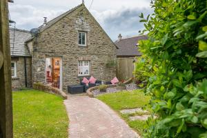 an old stone house with a garden in front of it at The Old Dairy in Haverfordwest