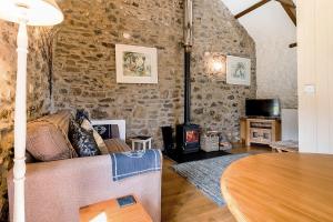 ein Wohnzimmer mit einem Tisch und einem Holzofen in der Unterkunft Little Rogeston Cottage in Haverfordwest
