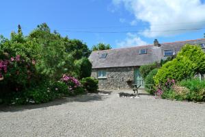 an old stone cottage with a gravel driveway at Rose Cottage in Solva +25 photos