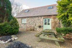 a picnic table in front of a stone cottage at Rose Cottage in Solva