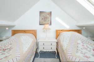 two beds sitting next to each other in a bedroom at Rose Cottage in Solva