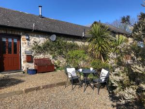 ein Tisch und Stühle vor einem Haus in der Unterkunft Little Rogeston Cottage in Haverfordwest