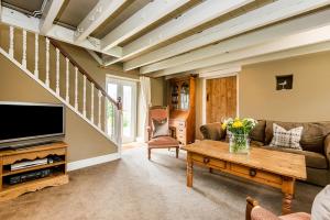 a living room with a couch and a tv at Kelwon Cottage in Saint Brides