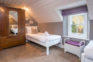 a bedroom with a bed and a dresser and a window at Kelwon Cottage in Saint Brides