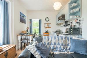 Una sala de estar con un sofá y una cocina. en Glen Holme, en Little Haven 11 fotos más