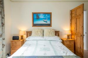 Un dormitorio con una cama grande con dos mesitas de noche. en Glen Holme, en Little Haven