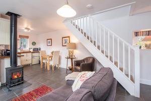 ein Wohnzimmer mit Couch und Kamin in der Unterkunft Llanmill Cottage in Lampeter-Velfrey