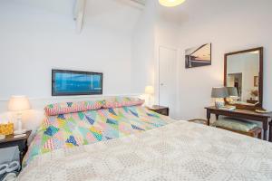 ein Schlafzimmer mit einem großen Bett mit einer bunten Bettdecke in der Unterkunft Llanmill Cottage in Lampeter-Velfrey