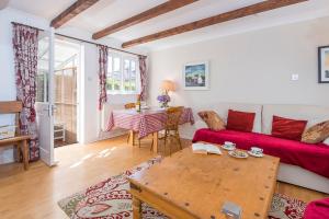 a living room with a red couch and a table at Willowcot Cottage in Haverfordwest