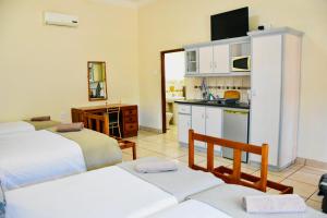 a living room with two beds and a kitchen at Donkin House in Beaufort West