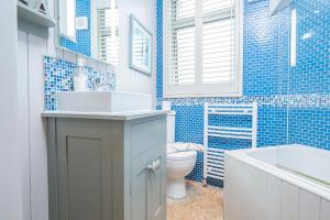 a bathroom with a sink and a toilet and a tub at Lower Deck in Tenby +21 photos