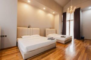 a bedroom with two beds and a chandelier at Gelugor 2Storey Big Bungalow 23pax with BBQ Snooker in Gelugor