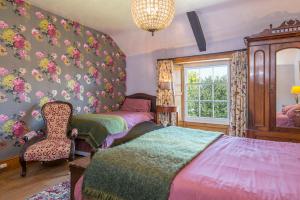 a bedroom with two beds and a chair and a window at Glebe House in Haverfordwest +32 photos