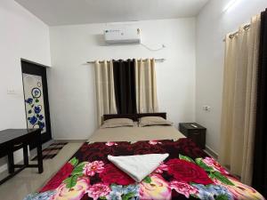 バルカラにあるPhoenix homestayのベッドルーム1室(花の毛布付きのベッド1台付)