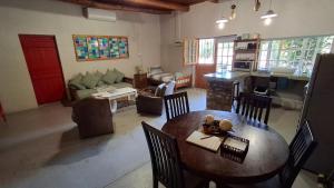 a living room with a table and chairs and a kitchen at Lentelus-Greeff Cottage in Oudtshoorn