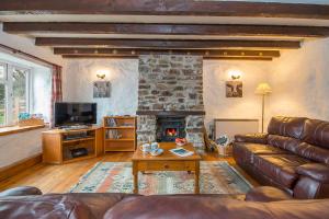 ein Wohnzimmer mit Couch und Kamin in der Unterkunft Honey Hook Cottage in Haverfordwest