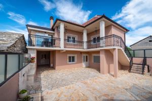 Cette grande maison dispose d'un balcon au-dessus d'une allée. dans l'établissement Atraktivna Villa Lana s dva bazena, à Dušić