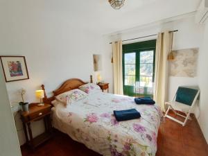 a bedroom with a bed and a chair and a window at La vista encantada in Frigiliana +12 photos