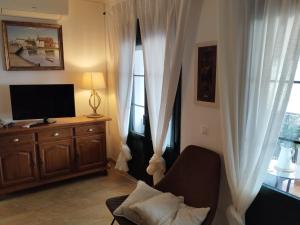 a living room with a television and white curtains at La vista encantada in Frigiliana
