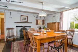 a dining room with a table and chairs and a fireplace at Ty Canol in Goodwick